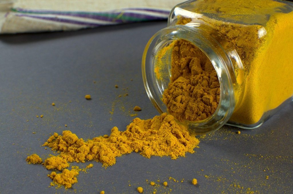 Curcuma in polvere accanto a un barattolo